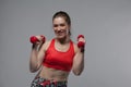 Smiling fitness woman posing with red dumbbells Royalty Free Stock Photo