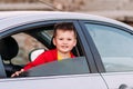 Smiling five-year-old boy looks out of the open car window Royalty Free Stock Photo