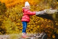 Smiling five year old girl in jacket on autumn yellow leaves background