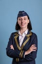Smiling flight attendant in professional uniform with crossed arms