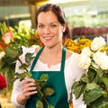 Smiling florist cutting rose flower shop woman