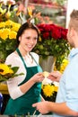 Smiling florist man customer buying flowers card