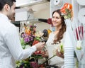 Woman seller offering flowers man