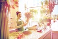 Smiling florist woman making bunch at flower shop