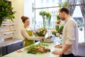 Smiling florist woman and man at flower shop