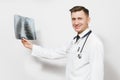 Smiling focused doctor man with X-ray of lungs, fluorography, roentgen isolated on white background. Male doctor in