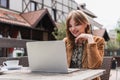 Smiling freelancer in earphone using laptop