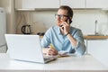 Smiling freelancer guy working from home, sits at the kitchen desk Royalty Free Stock Photo