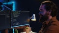 Smiling freelancing developer in home office doing coding on computer