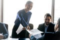 Smiling friendly businesswoman giving handout material to employee at meeting Royalty Free Stock Photo