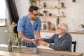 Smiling friendly caretaker serving breakfast to a pensioner