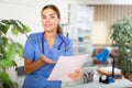 Friendly female doctor with papers explaining treatment procedure in office Royalty Free Stock Photo