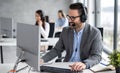 Smiling friendly handsome young male call centre operator working in customer support service Royalty Free Stock Photo