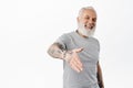 Smiling friendly mature man with tattoos give hand for handshake and laughing, nice to meet you gesture, meeting someone Royalty Free Stock Photo