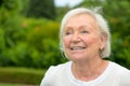 Smiling friendly 82 year old woman in her garden