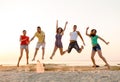 Smiling friends dancing and jumping on beach Royalty Free Stock Photo