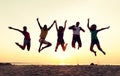 Smiling friends dancing and jumping on beach Royalty Free Stock Photo