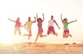 Smiling friends dancing and jumping on beach Royalty Free Stock Photo