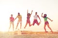 Smiling friends dancing and jumping on beach Royalty Free Stock Photo