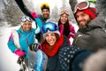 smiling friends having fun. Snowboarders and skiers making selfie