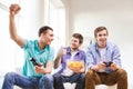 Smiling friends playing video games at home Royalty Free Stock Photo