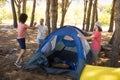 Smiling friends preparing tent