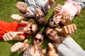 Smiling friends showing thumbs up lying on grass Royalty Free Stock Photo