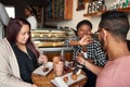 Smiling friends sitting at a cafe table eating desserts together Royalty Free Stock Photo