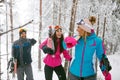 Smiling friends snowboarder or skiers going through in the fog w