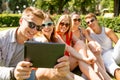 Smiling friends with tablet pc making selfie Royalty Free Stock Photo