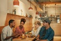 Smiling friends talking over drinks and food in a bistro Royalty Free Stock Photo