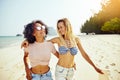 Smiling friends walking together along a tropical beach Royalty Free Stock Photo