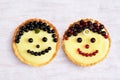 Smiling fruit cakes. Shortbread tartlets with vanilla custard cream, black and red currant and fruits of amelanchier