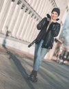 Smiling full length beautiful young woman standing on winter day outdoors. Pretty girl wearing warm clothing Royalty Free Stock Photo