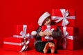 Smiling funny child in Santa red hat holding Christmas gift in hand. Christmas concept. Royalty Free Stock Photo