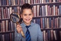 Smiling funny first-grader with a magnifying glass Royalty Free Stock Photo