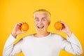 Smiling funny man with oranges in hands. Handsome young man hold fresh natural orange. Man enjoying fruit refreshment