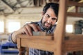 Smiling furniture maker sanding a chair in his workshop Royalty Free Stock Photo