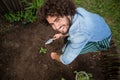 Smiling gardener planting outside greenhouse