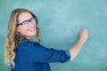 Smiling geeky teacher writing on blackboard