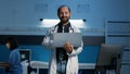 Smiling general practitioner wearing medical white coat and stethoscope holding laptop computer Royalty Free Stock Photo