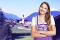 Smiling german woman in bavarian dirndl with rural landscape