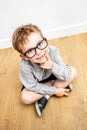 Smiling gifted boy with smart eyeglasses and tooth missing seated