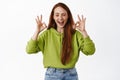 Smiling ginger girl laughing, showing okay OK signs and look happy, approve and say no proble, like and praise something