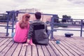 Smiling ginger girl in pink hoodie sitting close to her short-haired boyfriend