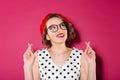 Smiling ginger woman in dress and eyeglasses praying