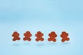 Smiling gingerbread mans made of modeling clay floating and dancing on the blue background. Winter christmas decoration christmas