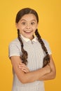 Smiling girl. Adorable schoolgirl yellow background. Little girl. Happy childrens day. Tidy girl nice hairstyle Royalty Free Stock Photo