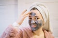 Smiling girl applying mud cream on her forehead Royalty Free Stock Photo