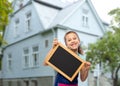 smiling girl in apron with chalkboard over house Royalty Free Stock Photo